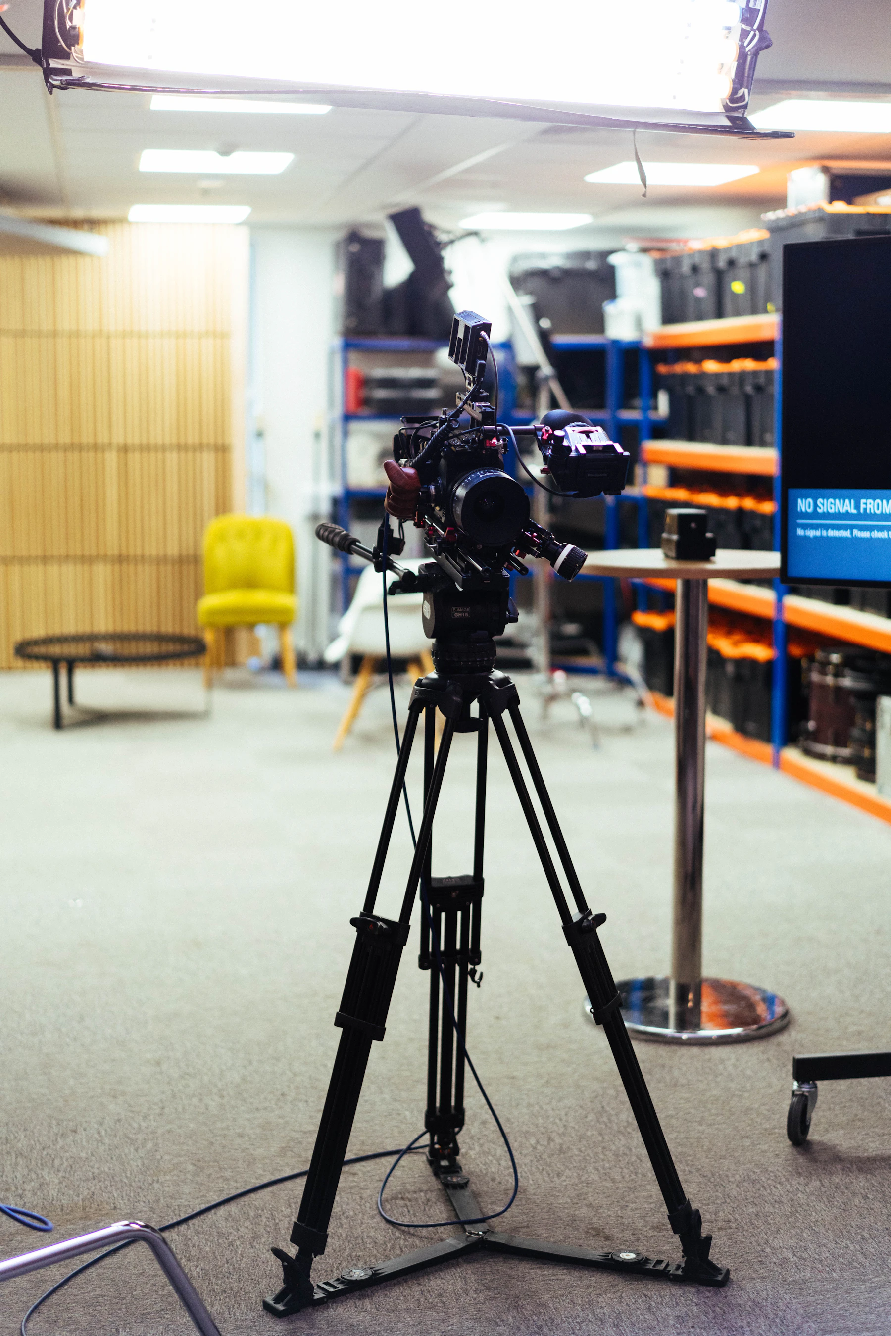 Professional video camera and prompting setup in a blue-lit studio